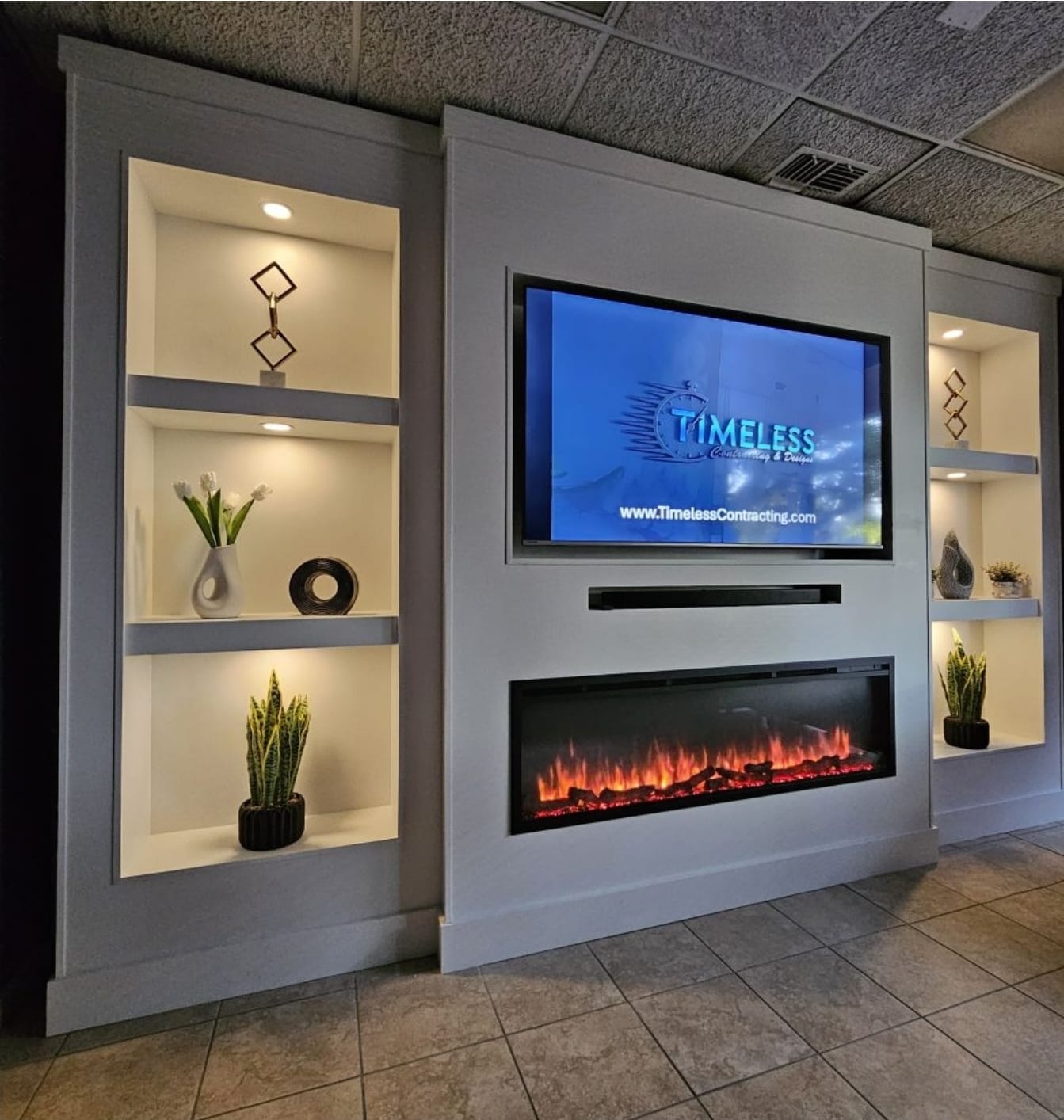 Custom built-in media wall with recessed LED-lit shelves, electric fireplace, and wall-mounted TV.
